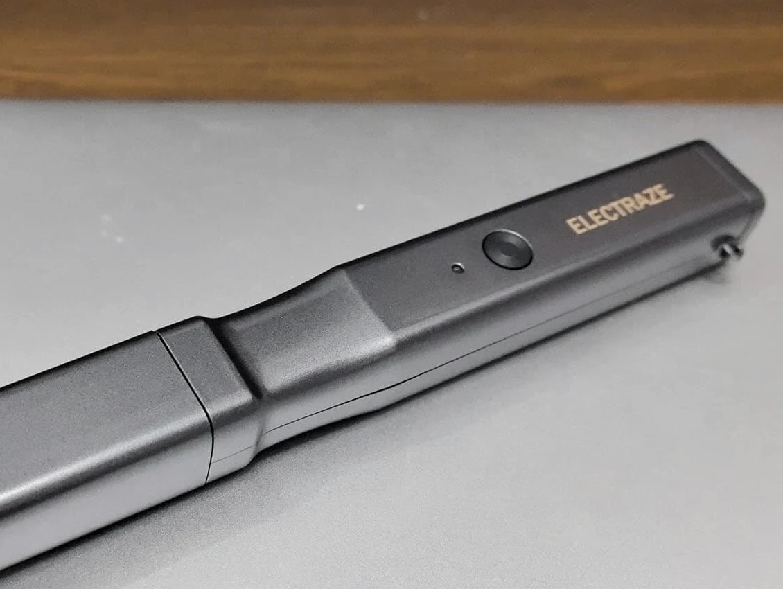 Close view of the slim black SonicCutter housing, control button and fitted protective cap